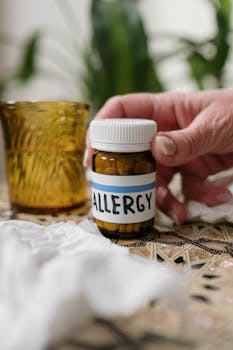 Close-up of allergy medication bottle with tissues and amber glass indoors.