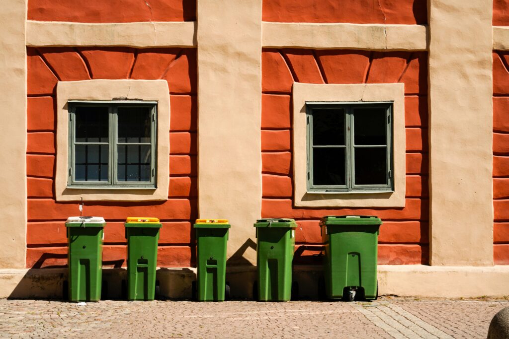 Bright urban wall with recycling bins lined up on a sunny day.