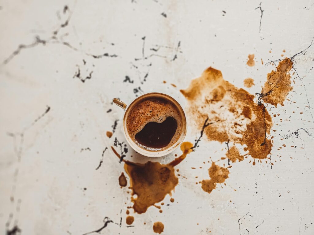 A top view of a Turkish coffee cup with spills on a marble surface, capturing the traditional beverage's essence.